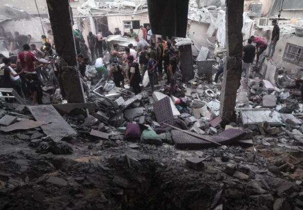 Palestinians look for survivors under the rubble of a destroyed house following an Israeli airstrike in Khan Younis refugee camp, southern Gaza Strip, on November 13, 2023. Photo: AP.