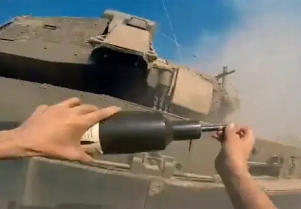Resistance fighter placing a bomb on an Israeli Merkava tank. Photo: Palestinian Resistance footage.