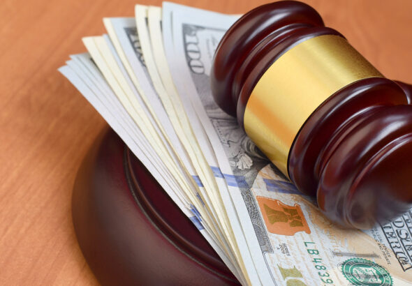 Judge's gavel laying on a pack of $100 bills. Photo: File photo.