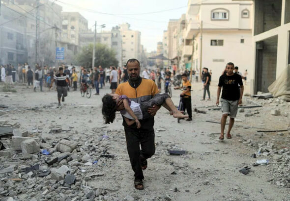 Calling Israel’s bombing of Palestinian civilians an act of ‘self-defence’ is a disingenuous labelling of Israel’s actions: a Palestinian man carries a wounded girl at the site of Israeli strikes, in Khan Younis in the southern Gaza Strip, October 14, 2023. Photo: Reuters.