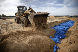 Palestinians bury innocent civilians killed by the Israeli entity's genocidal bombardment in a mass grave in the town of Khan Younis, southern Gaza Strip, Wednesday, Nov. 22, 2023. Photo: Mohammed Dahman/AP.