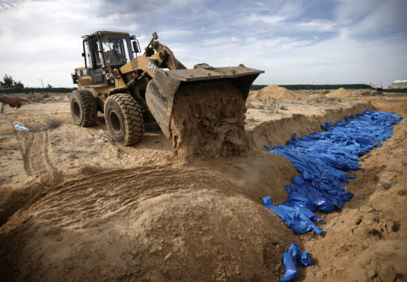 Palestinians bury innocent civilians killed by the Israeli entity's genocidal bombardment in a mass grave in the town of Khan Younis, southern Gaza Strip, Wednesday, Nov. 22, 2023. Photo: Mohammed Dahman/AP.