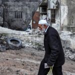 An elderly Palestinian man walks through the destroyed Al Maghazi refugee camp in central Gaza, December 2023. Photo: Middle East Eye.