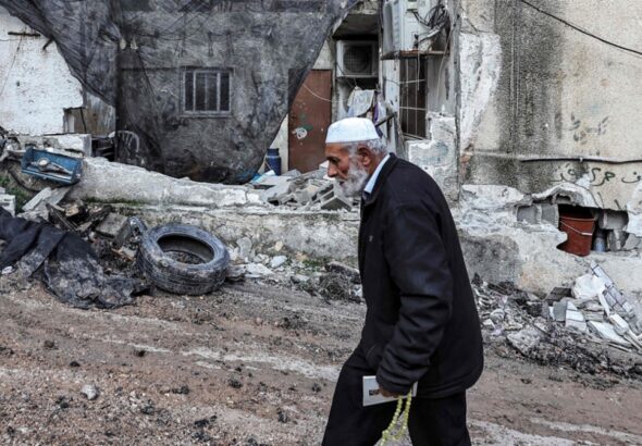 An elderly Palestinian man walks through the destroyed Al Maghazi refugee camp in central Gaza, December 2023. Photo: Middle East Eye.