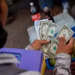 Street vendor counting US dollars along with bolívars. File photo.