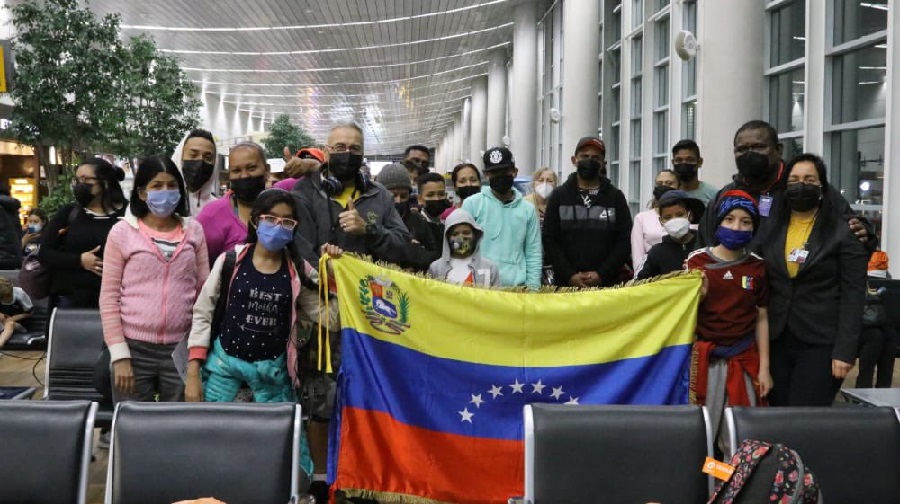 Venezuelan migrants returning to their country through the government's Vuelta a la Patria program pose with the flag of Venezuela. File photo.