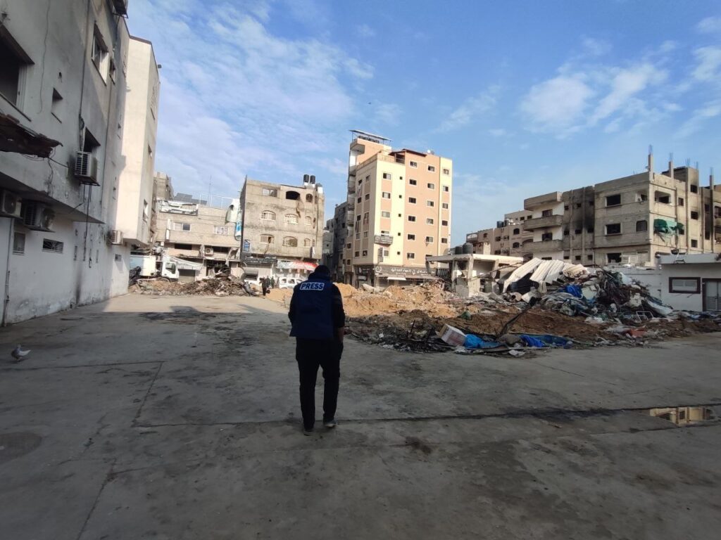 Journalist Yousef Fares stands in front of a destroyed city block in Northern Gaza on December 28, 2023. Photo: Yousef Fares Telegram.