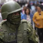 Featured image: Ecuadorian soldier on a crowded street. Photo: Dolores Ochoa/AP.