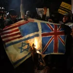 Iranian protesters burn flags of US, UK, and "Israel." Photo: AFP.