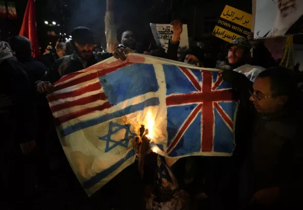 Iranian protesters burn flags of US, UK, and "Israel." Photo: AFP.
