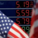 Prices of gas at a US gas station next to US flags. Photo: Mike Segar/Reuters/File photo.