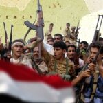 Photo composition showing Yemeni fighters raising their machine guns next to the Yemen flag with the map of Yemen in the background. Photo: Al Mayadeen.