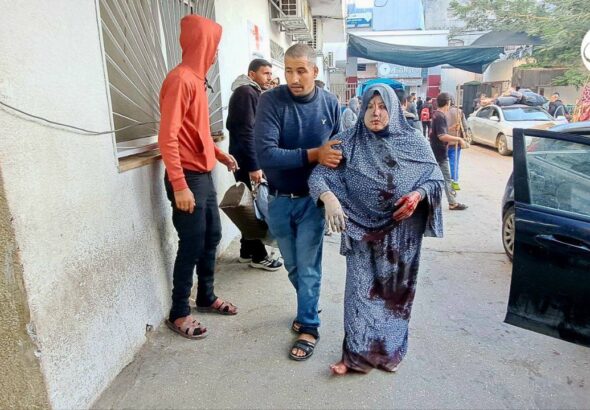 A woman injured in Israeli airstrike being escorted to the Kamal Adwan hospital, northern Gaza, December 2023. Photo: Social media.