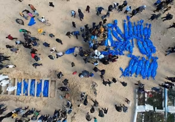 Palestinians victims of Israeli genocide being buried in blue bags. Photo: The Palestine Information Center.