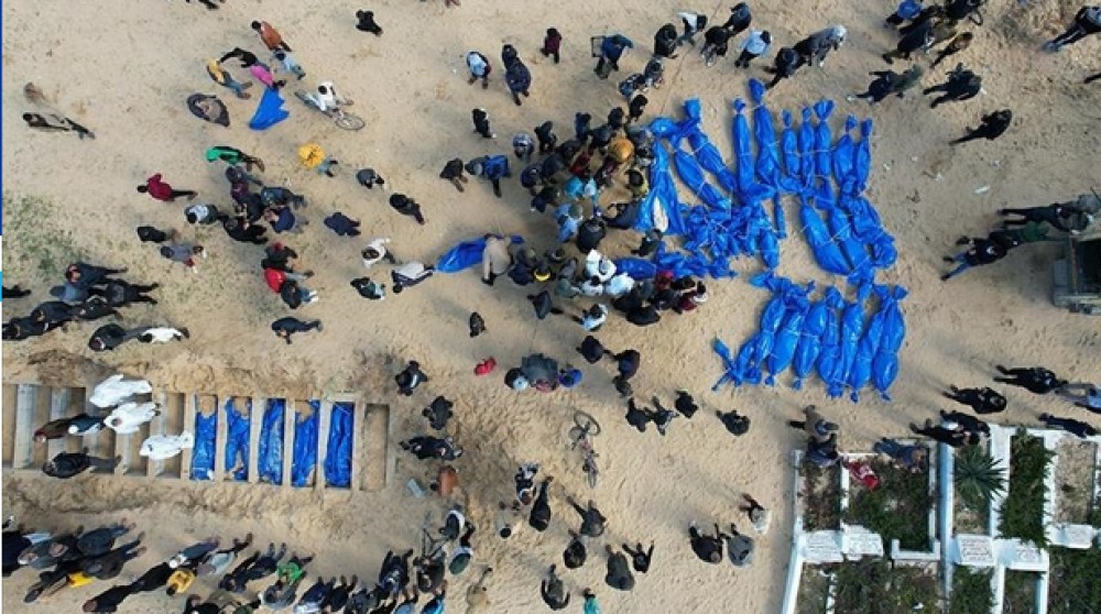 Palestinians victims of Israeli genocide being buried in blue bags. Photo: The Palestine Information Center.