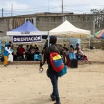 A person with a backpack with the Venezuelan flag colors approaches a UNHCR tent. Photo: Fernanda Pineda/Amnesty International.
