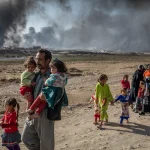 An Iraqi family displaced by fighting in the village of Shora walks towards an Iraqi army checkpoint near Qayyarah. Photo: UNHCR/Ivor Prickett.