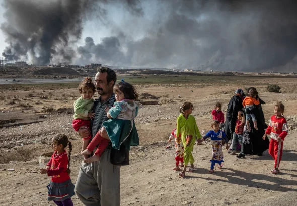 An Iraqi family displaced by fighting in the village of Shora walks towards an Iraqi army checkpoint near Qayyarah. Photo: UNHCR/Ivor Prickett.