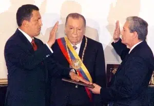 "I swear in front of my people, that over this moribund constitution, I will push forward the democratic transformations that are necessary," says Hugo Chávez (left) as he is being sworn in by President of Congress Luis Dávila (right), while outgoing President Rafael Caldera (center) observes, February 2, 1999. Photo: Reuters/File photo.