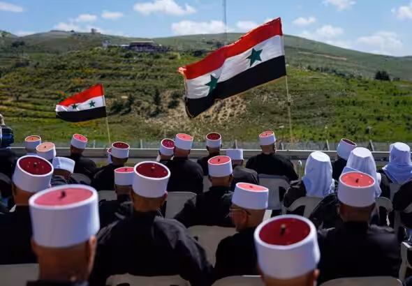 Druze men sit with Syrian flags during a rally marking Syria's Independence Day, in the Druze village of Majdal Shams in the Israeli-occupied Golan Heights, on the border with Syria, Monday, April 17, 2023. Photo: AP.