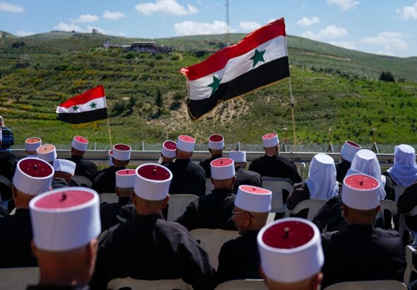 Druze men sit with Syrian flags during a rally marking Syria's Independence Day, in the Druze village of Majdal Shams in the Israeli-occupied Golan Heights, on the border with Syria, Monday, April 17, 2023. Photo: AP.