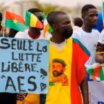 A supporter of the Alliance Of Sahel States (ASS) holds a placard reading 'only the struggle set free' during a rally to celebrate Mali, Burkina Faso and Niger leaving the Economic Community of West African States (ECOWAS) in Bamako on February 1, 2024. Photo: Ousmane MakaveliI/AFP.