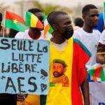A supporter of the Alliance Of Sahel States (ASS) holds a placard reading 'only the struggle set free' during a rally to celebrate Mali, Burkina Faso and Niger leaving the Economic Community of West African States (ECOWAS) in Bamako on February 1, 2024. Photo: Ousmane MakaveliI/AFP.