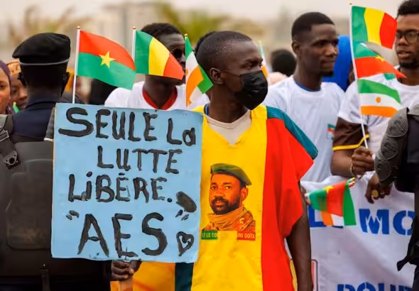A supporter of the Alliance Of Sahel States (ASS) holds a placard reading 'only the struggle set free' during a rally to celebrate Mali, Burkina Faso and Niger leaving the Economic Community of West African States (ECOWAS) in Bamako on February 1, 2024. Photo: Ousmane MakaveliI/AFP.