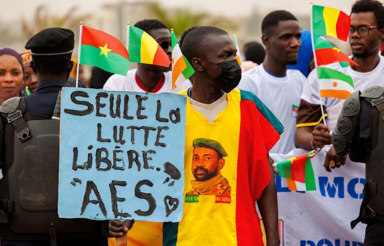 A supporter of the Alliance Of Sahel States (ASS) holds a placard reading 'only the struggle set free' during a rally to celebrate Mali, Burkina Faso and Niger leaving the Economic Community of West African States (ECOWAS) in Bamako on February 1, 2024. Photo: Ousmane MakaveliI/AFP.