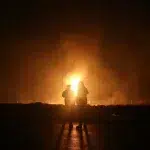 Two people in complete darkness observe an explosion. Photo: Reza Kamali Dehkordi/Fars News Agency.