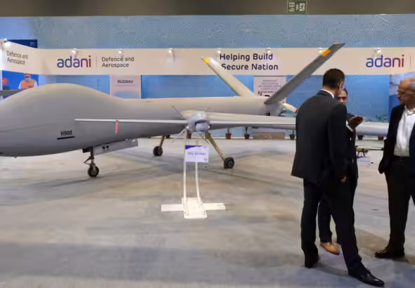 Delegates in front of Adani Defence and Aerospace's Hermes 900, left, and Sky Striker, center, drones on display at the Drone Festival - Bharat Drone Mahotsav 2022, at Pragati Maidan in New Delhi, India. Photo: Bloomberg.