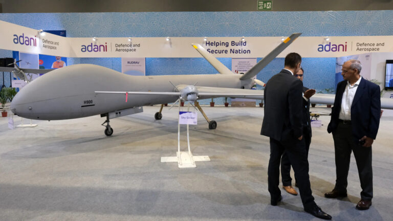Delegates in front of Adani Defence and Aerospace's Hermes 900, left, and Sky Striker, center, drones on display at the Drone Festival - Bharat Drone Mahotsav 2022, at Pragati Maidan in New Delhi, India. Photo: Bloomberg.