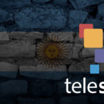 Photo composition showing the logo of Telesur over a transparent flag of Argentina on a wall of stone. Photo: Telesur/File photo.