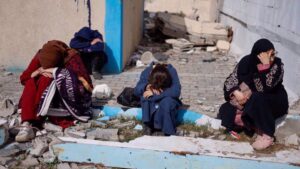 Palestinians rest next to damaged buildings after arriving in Rafah after they were evacuated from Nasser Hospital in Khan Younis in the southern Gaza Strip on February 4, 2024. Photo: Reuters.