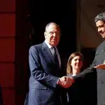 Venezuela's President Nicolás Maduro shakes hands with Russia's Foreign Minister Sergei Lavrov after meeting in Caracas, Venezuela, February 20, 2024. Photo: Leonardo Fernandez Viloria/Reuters.