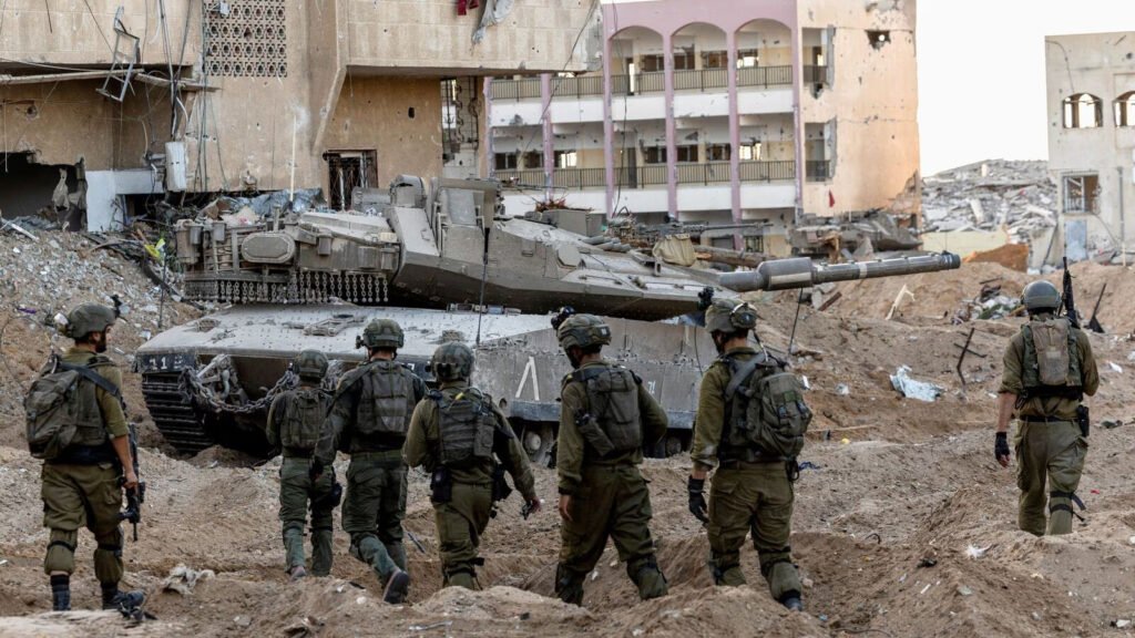 Israeli army personnel and a tank in a detsroyed neighborhood of Gaza City. Photo: Reuters.