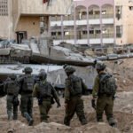 Israeli army personnel and a tank in a detsroyed neighborhood of Gaza City. Photo: Reuters.