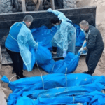The photo shows people lowering the bodies of deceased Palestinians into a mass grave, wrapped in blue bags. Photo: Eye on Palestine.