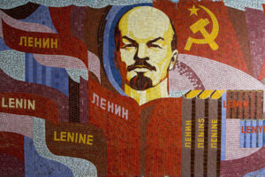 Poster showing Lenin, the Communist symbol, and books with Lenin's name in different languages. Photo: Soviet Artefacts.