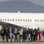 Featured image: Migrants walking near an airplane. Photo: EFE/File photo.