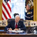 US President Joe Biden signs executive actions in the Oval Office of the White House in Washington on Jan. 26. Photo: Doug Mills/The New York Times.