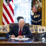 US President Joe Biden signs executive actions in the Oval Office of the White House in Washington on Jan. 26. Photo: Doug Mills/The New York Times.