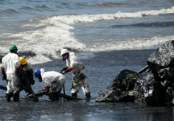 Workers of Heritage Petroleum Oil and Gas Company clean up the oil spill that reached Rockly Bay beach, in Scarborough, southwestern Tobago, Trinidad and Tobago, February 11, 2024. Photo: AP/Akash Boodan.