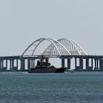 A Russian Navy amphibious landing ship that was deployed to transport cars across the Kerch Strait, sails past the Crimean Bridge in Kerch, Republic of Crimea, Russia. Photo: Sputnik/Konstantin Mihalchevskiy.