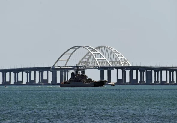 A Russian Navy amphibious landing ship that was deployed to transport cars across the Kerch Strait, sails past the Crimean Bridge in Kerch, Republic of Crimea, Russia. Photo: Sputnik/Konstantin Mihalchevskiy.