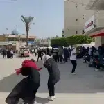 People covering themselves immediately after the blast caused by the Israeli bombing next to the Al-Aqsa Martyrs’ Hospital in Deir Al-Balah, in central Gaza, Palestine on Sunday, March 31, 2024. Photo: Screenshot of social media video by @PalestineChron.