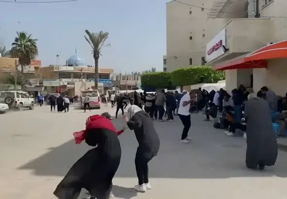 People covering themselves immediately after the blast caused by the Israeli bombing next to the Al-Aqsa Martyrs’ Hospital in Deir Al-Balah, in central Gaza, Palestine on Sunday, March 31, 2024. Photo: Screenshot of social media video by @PalestineChron.