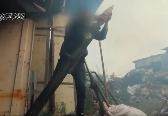 A fighter from Hamas al-Qassam Brigades drops a 120mm mortar shell to fire at gropings of Israeli troops to the southeast of al-Zaytoun, Gaza City, the Gaza Strip, this footage was published on February 28, 2024. Photo: Al-Qassam Brigades/Military Media.