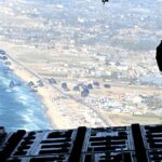 A US Air Force loadmaster releases humanitarian aid pallets over Gaza on March 2, 2024. Photo:  Christopher Hubenthal/US Air Force via Reuters.