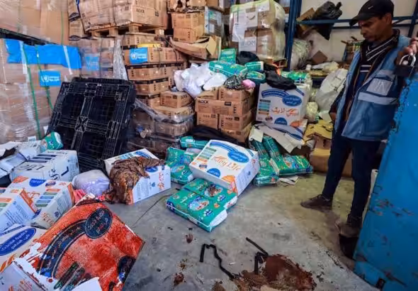 A UNRWA staff stands near a pool of blood at a UNRWA warehouse and distribution center in Rafah, in the southern Gaza strip, following an Israeli strike on March, 13, 2024. Photo: AFP.